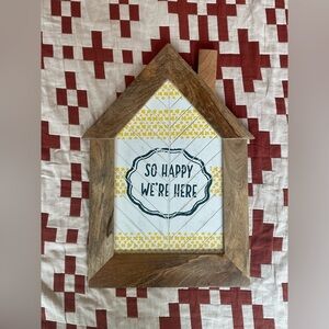“So happy we’re here” wood sign